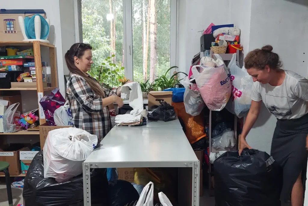 Волонтёры раскладывают вещи в социальном складе «Есть дело» в Новосибирске. Фото: предоставлено фондом.