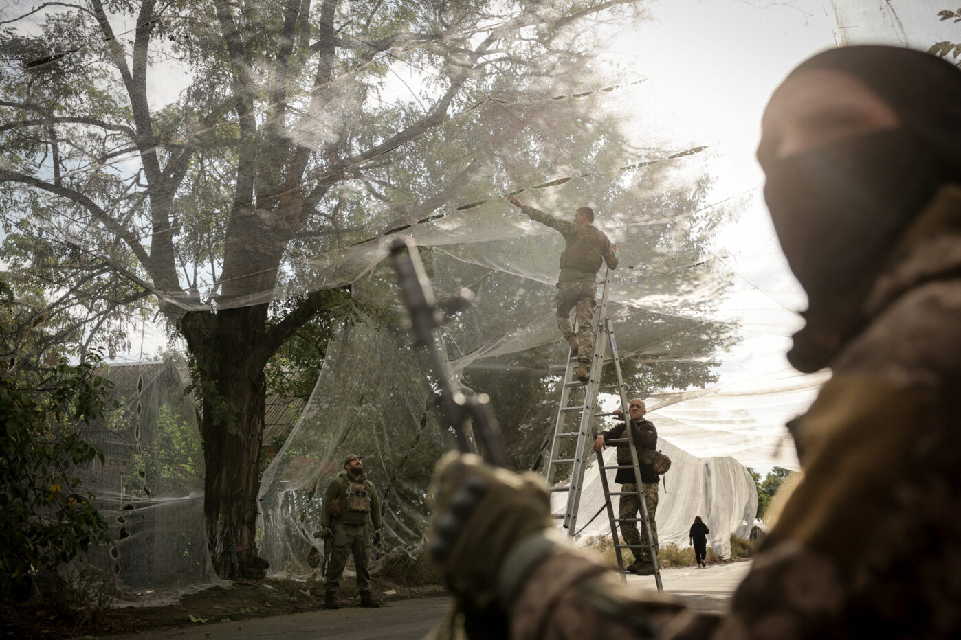 Ukrainian military personnel install anti-drone nets over a road in the frontline town of Konstantinovka, Donetsk region, Ukraine