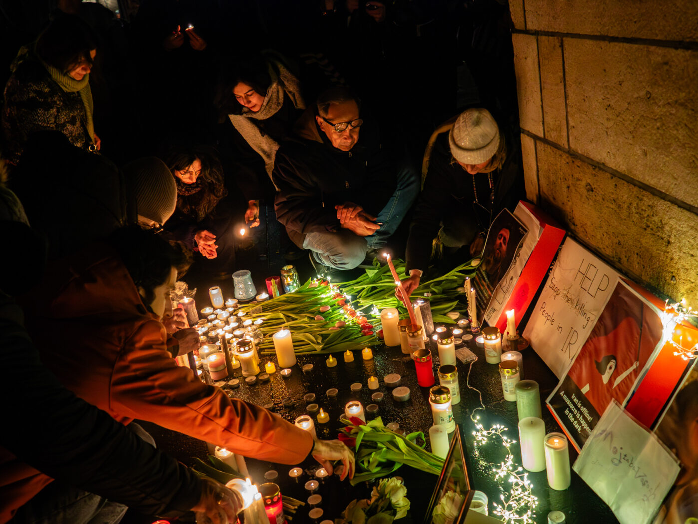 В память о погибших во время протестов в Иране, люди в Утрехте приносят свечи